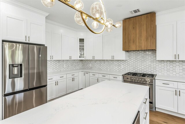 9 Vista Ln, Levittown, NY 11756 - kitchen with stainless steel appliances, white cabinets, glass insert cabinets, and crown molding