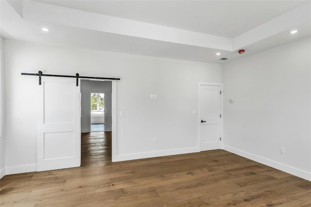 9 Vista Ln, Levittown, NY 11756 - unfurnished room featuring a barn door, recessed lighting, baseboards, and wood finished floors