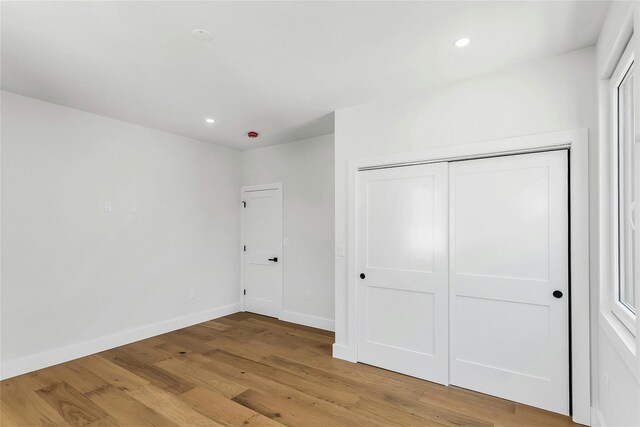 9 Vista Ln, Levittown, NY 11756 - unfurnished bedroom with light wood finished floors, baseboards, recessed lighting, and a closet