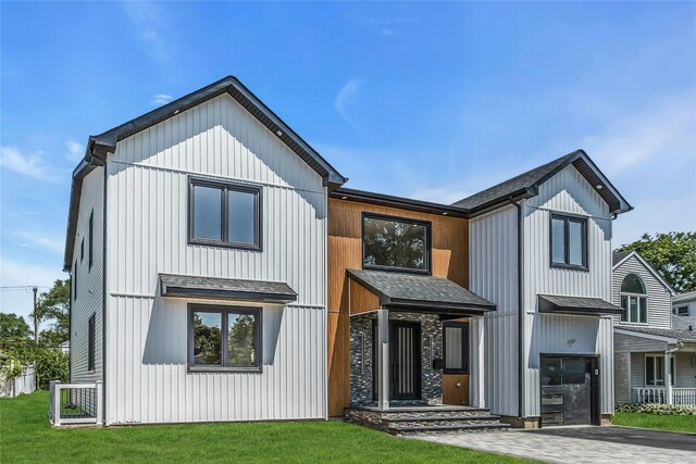 9 Vista Ln, Levittown, NY 11756 - modern farmhouse style home featuring an attached garage, a front yard, roof with shingles, and driveway