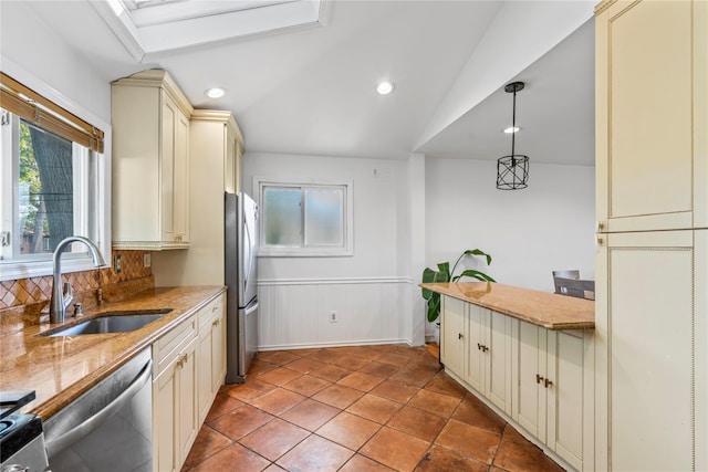 402 Chelsea Ave, West Babylon, NY 11704 - kitchen with cream cabinets, a sink, appliances with stainless steel finishes, healthy amount of natural light, and vaulted ceiling