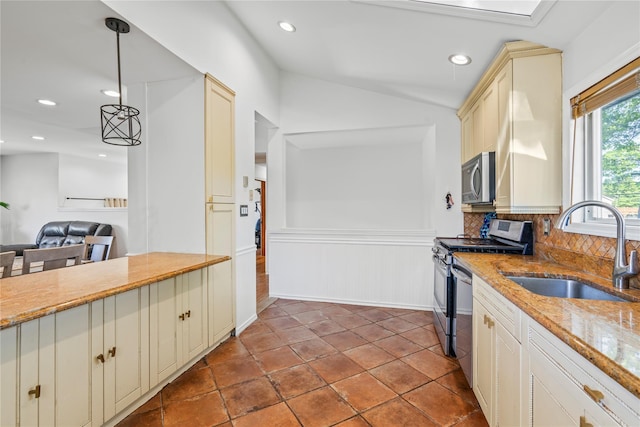 402 Chelsea Ave, West Babylon, NY 11704 - kitchen featuring a sink, cream cabinetry, appliances with stainless steel finishes, hanging light fixtures, and light stone counters