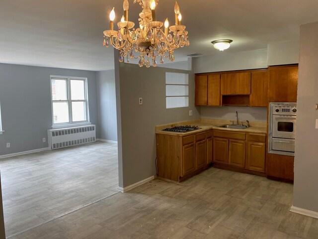 644 Autumn Ave, Brooklyn, NY 11208 - kitchen with radiator heating unit, stainless steel oven, light countertops, brown cabinetry, and gas cooktop