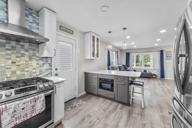 226 Mile Square Rd, Yonkers, NY 10701 - kitchen featuring wall chimney range hood, appliances with stainless steel finishes, open floor plan, white cabinets, and recessed lighting