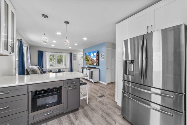 226 Mile Square Rd, Yonkers, NY 10701 - kitchen with stainless steel fridge, gray cabinetry, wall oven, white cabinets, and light wood-style floors