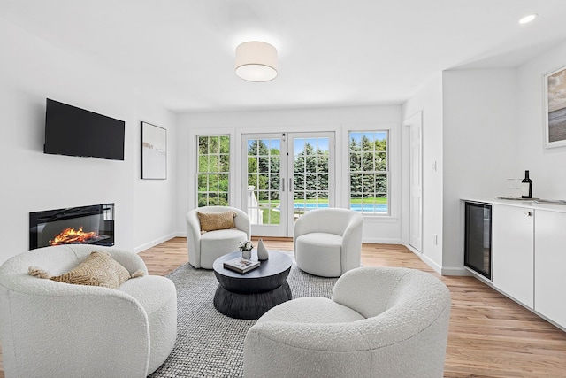 2850 Reeve Rd, Mattituck, NY 11952 - living room featuring wine cooler, a glass covered fireplace, light wood finished floors, and bar