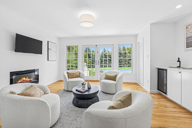 2850 Reeve Rd, Mattituck, NY 11952 - living area featuring wine cooler, bar area, a glass covered fireplace, and light wood-style floors