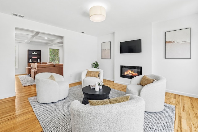 2850 Reeve Rd, Mattituck, NY 11952 - living room featuring a glass covered fireplace, light wood-type flooring, coffered ceiling, and beam ceiling
