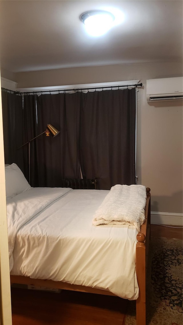 1026 Logan Ave, Bronx, NY 10465 - bedroom with an AC wall unit, wood finished floors, and baseboards