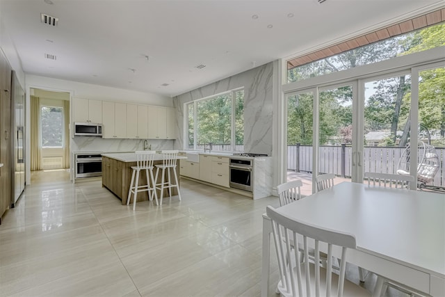 21 Dale Rd, Monsey, NY 10952 - kitchen featuring appliances with stainless steel finishes, light tile patterned flooring, a kitchen island, light countertops, and white cabinets