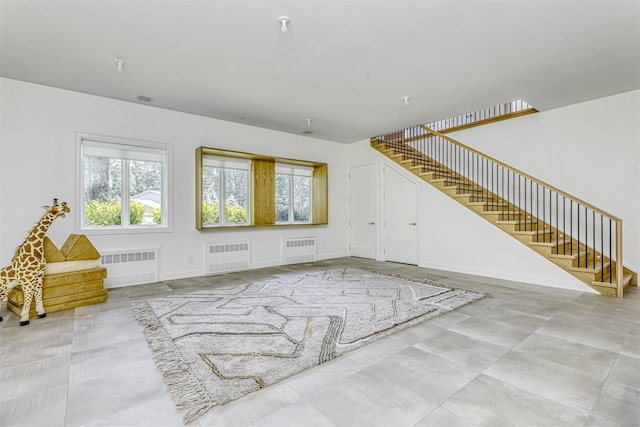 21 Dale Rd, Monsey, NY 10952 - unfurnished living room with radiator, stairs, and plenty of natural light