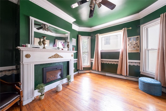 786 N Broadway, Yonkers, NY 10701 - living room featuring a lit fireplace, a ceiling fan, wood finished floors, a baseboard heating unit, and crown molding