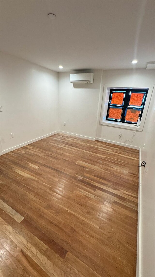 31 Roosevelt Pl, Brooklyn, NY 11233 - unfurnished room featuring wood finished floors, a wall unit AC, and recessed lighting