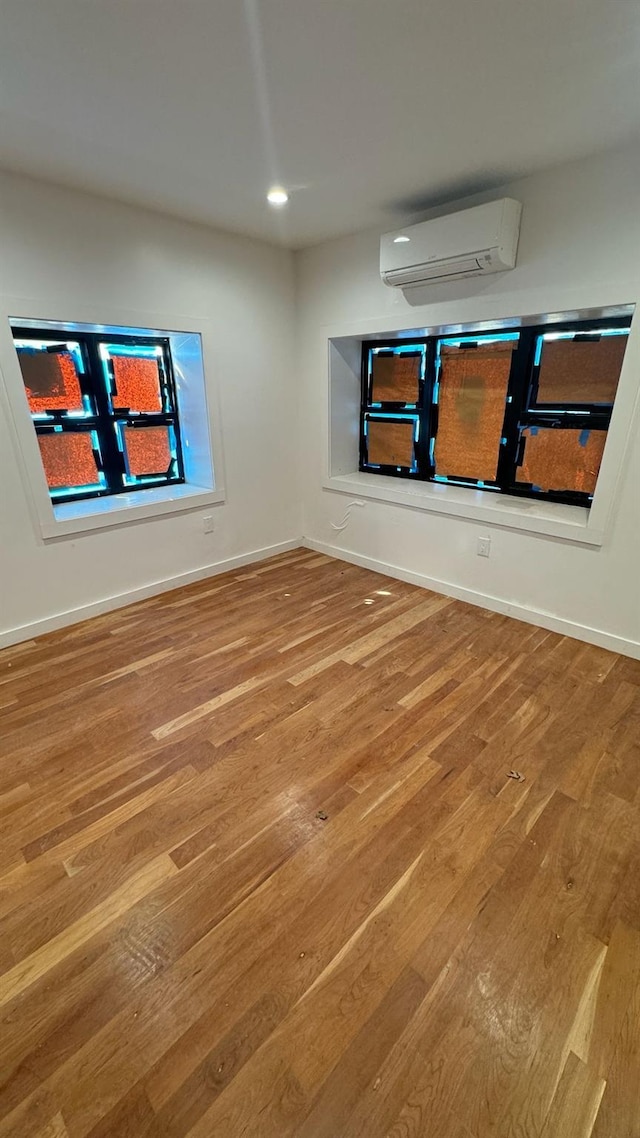 31 Roosevelt Pl, Brooklyn, NY 11233 - empty room featuring a wall unit AC, wood finished floors, and recessed lighting