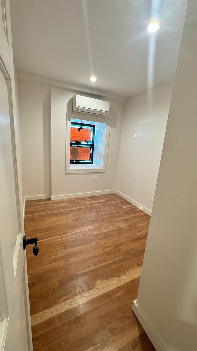 31 Roosevelt Pl, Brooklyn, NY 11233 - unfurnished room with an AC wall unit, recessed lighting, and wood finished floors