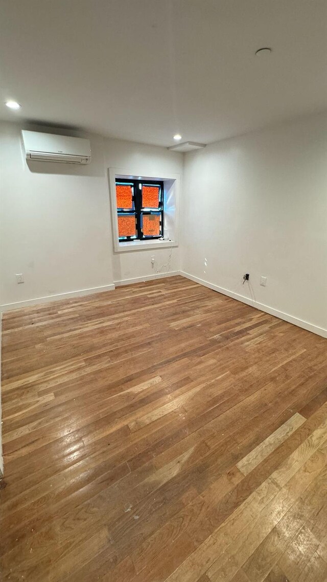 31 Roosevelt Pl, Brooklyn, NY 11233 - empty room featuring a wall mounted AC, hardwood / wood-style flooring, and recessed lighting