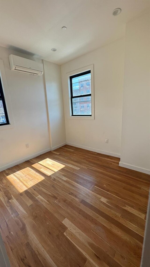 31 Roosevelt Pl, Brooklyn, NY 11233 - unfurnished bedroom featuring a wall mounted AC and wood finished floors
