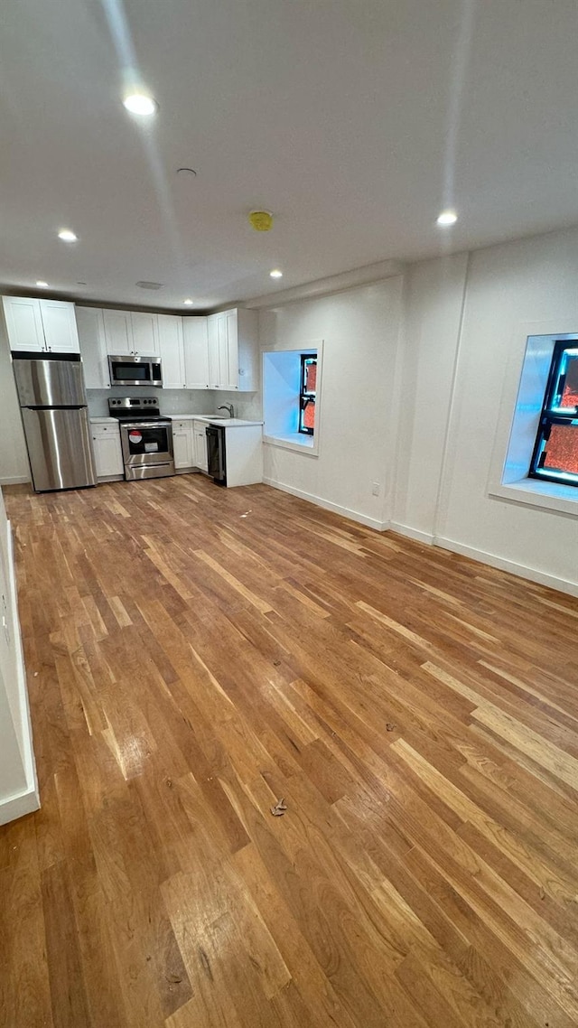 31 Roosevelt Pl, Brooklyn, NY 11233 - unfurnished living room featuring light wood-style floors and recessed lighting