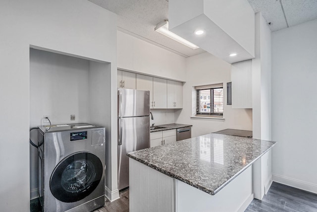 725 Miller Ave Unit 134, Freeport, NY 11520 - kitchen featuring washer / dryer, appliances with stainless steel finishes, a peninsula, dark wood finished floors, and white cabinetry