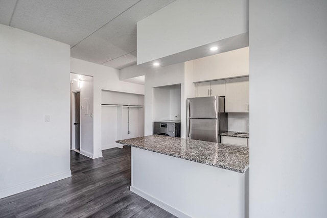 725 Miller Ave Unit 134, Freeport, NY 11520 - kitchen with freestanding refrigerator, dark wood finished floors, baseboards, recessed lighting, and dark stone counters