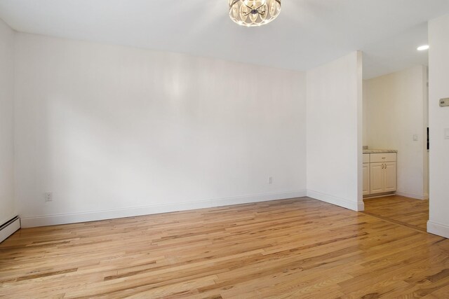 16 Sampson Ave, Islandia, NY 11749 - unfurnished room featuring light wood finished floors, baseboards, and a chandelier
