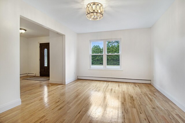 16 Sampson Ave, Islandia, NY 11749 - empty room with a baseboard radiator, hardwood / wood-style floors, a chandelier, and baseboards