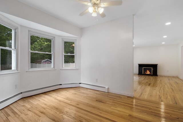 16 Sampson Ave, Islandia, NY 11749 - unfurnished living room featuring light wood-type flooring, a ceiling fan, a warm lit fireplace, baseboards, and recessed lighting