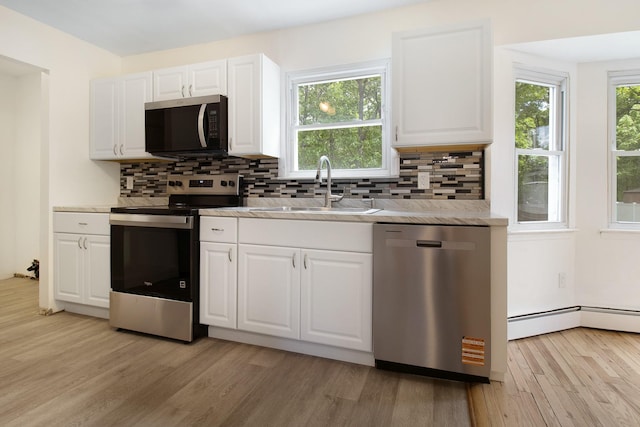 16 Sampson Ave, Islandia, NY 11749 - kitchen featuring appliances with stainless steel finishes, a sink, light wood finished floors, and decorative backsplash