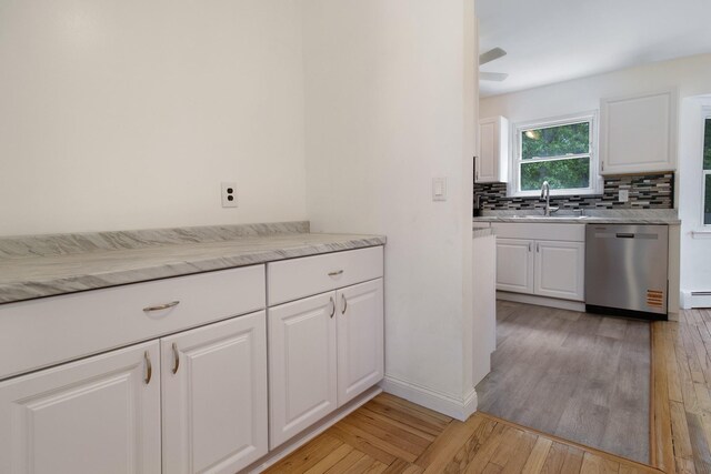 16 Sampson Ave, Islandia, NY 11749 - kitchen featuring stainless steel dishwasher, tasteful backsplash, light wood-style floors, and white cabinets