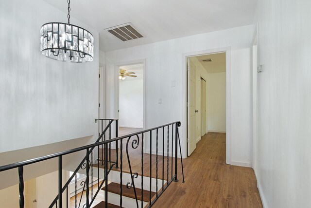 16 Sampson Ave, Islandia, NY 11749 - hall featuring an upstairs landing, wood finished floors, baseboards, and a chandelier