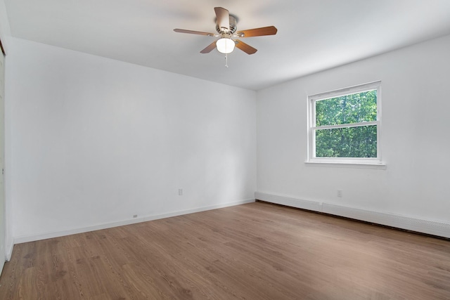 16 Sampson Ave, Islandia, NY 11749 - spare room featuring wood finished floors, ceiling fan, baseboards, and baseboard heating