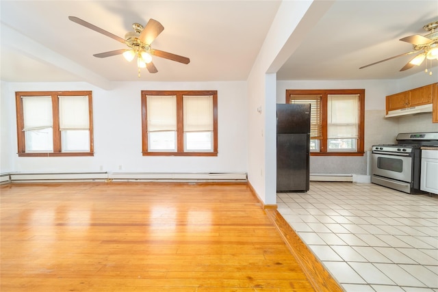 124-01 9th Ave, College Point, NY 11356 - kitchen featuring stainless steel range with gas cooktop, freestanding refrigerator, ceiling fan, under cabinet range hood, and a baseboard radiator