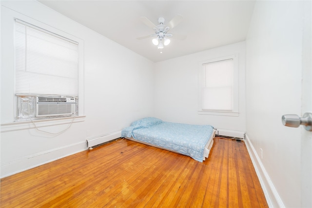 124-01 9th Ave, College Point, NY 11356 - bedroom with a baseboard heating unit, baseboards, light wood-type flooring, a ceiling fan, and cooling unit