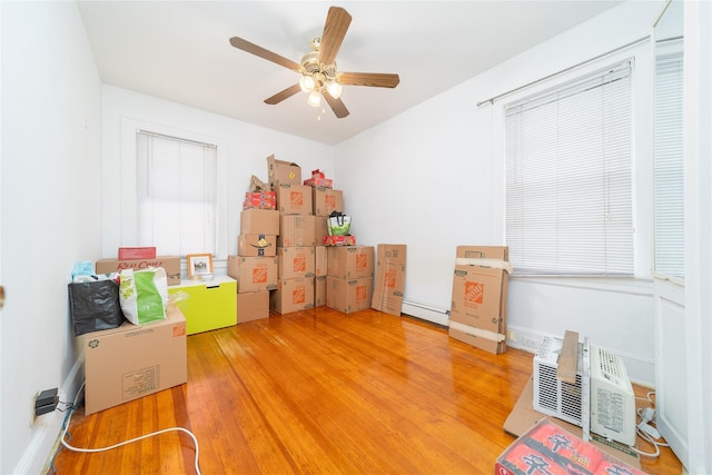 124-01 9th Ave, College Point, NY 11356 - bedroom with light wood-type flooring, a baseboard heating unit, a wall mounted air conditioner, and ceiling fan