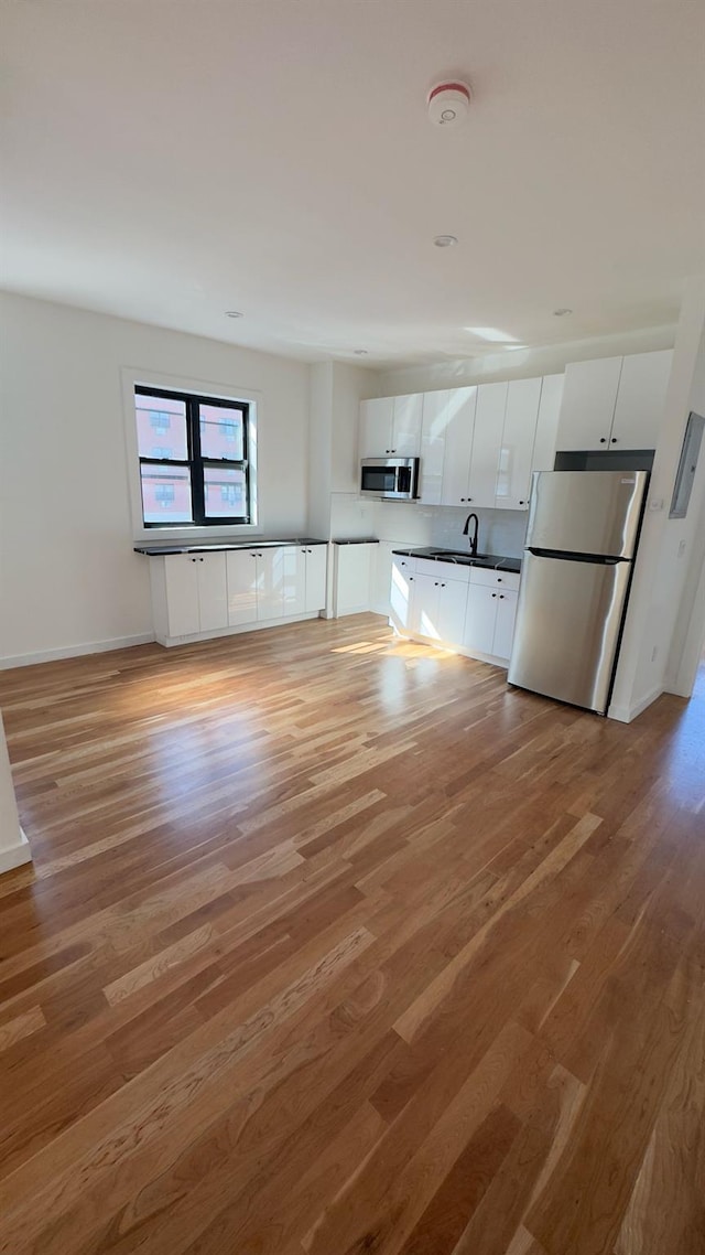 32 Radde Pl, Brooklyn, NY 11233 - unfurnished living room with light wood-type flooring