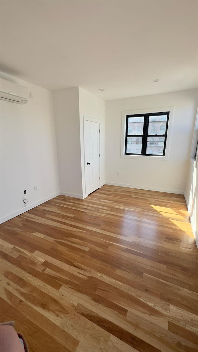 32 Radde Pl, Brooklyn, NY 11233 - unfurnished room with a wall mounted air conditioner and light wood-style floors