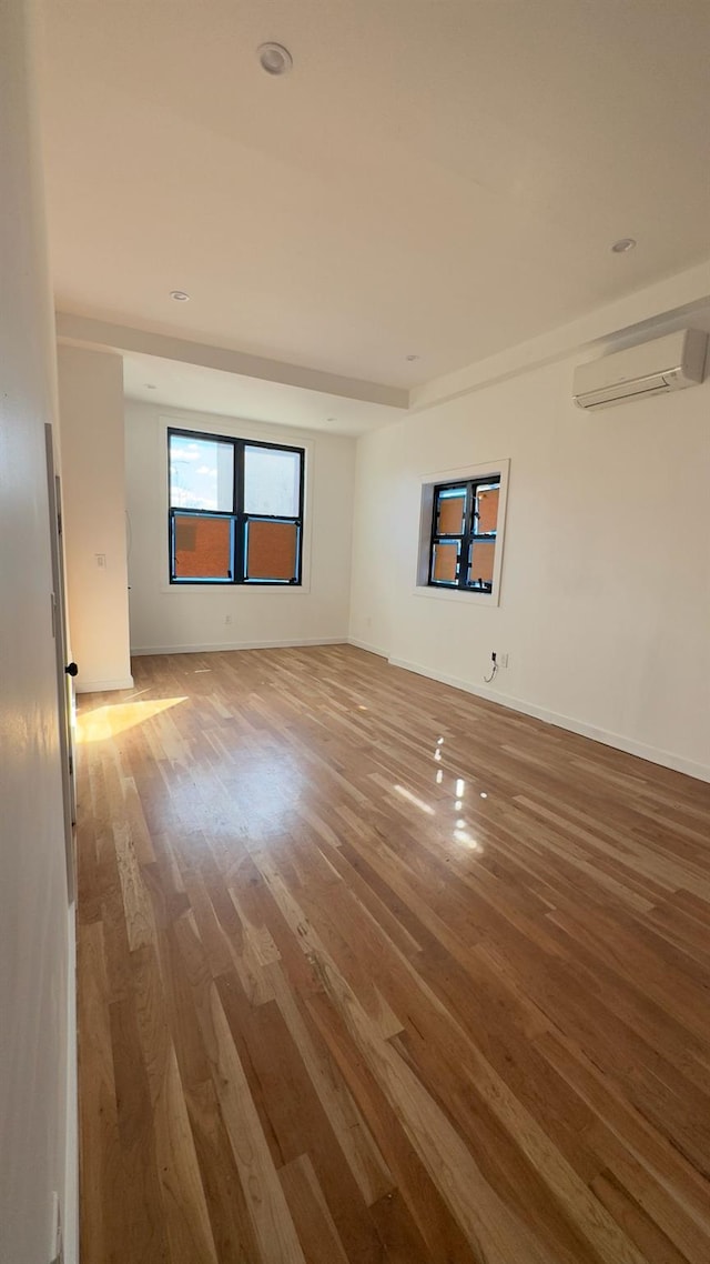 32 Radde Pl, Brooklyn, NY 11233 - spare room featuring an AC wall unit and wood finished floors