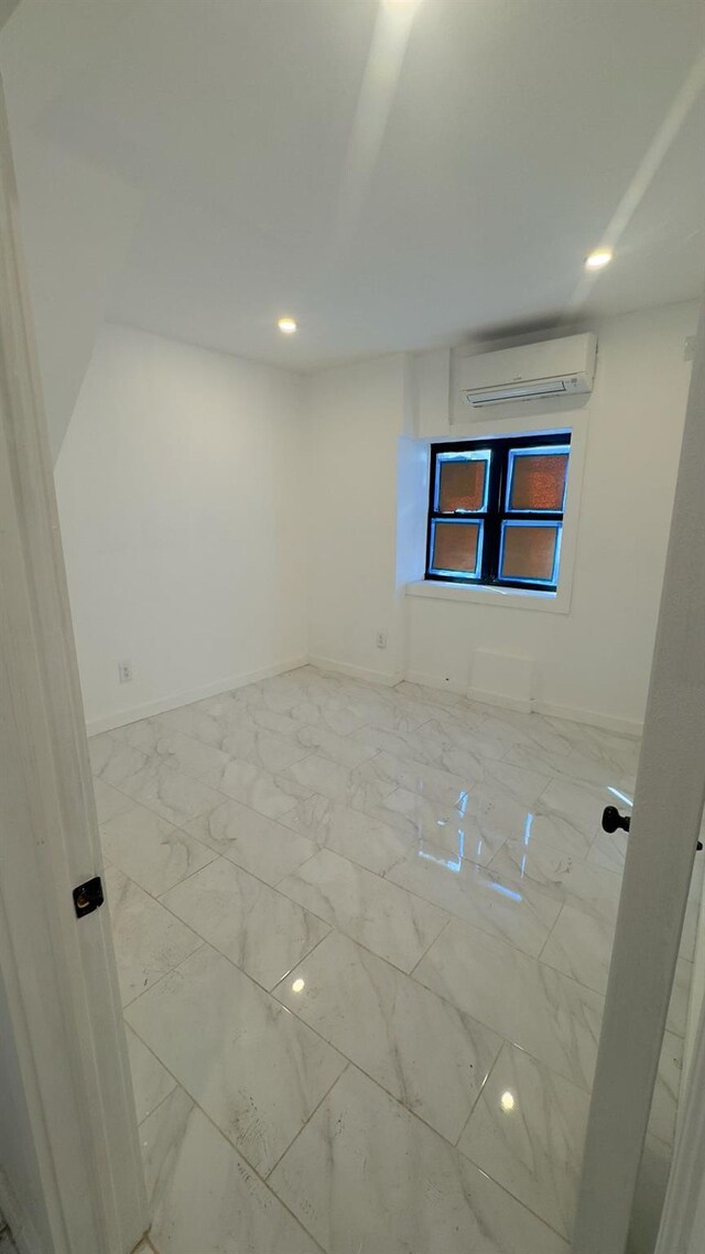 32 Radde Pl, Brooklyn, NY 11233 - spare room featuring an AC wall unit, marble look tiles, and recessed lighting