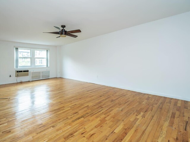 32 Pearsall Ave Unit 3A, Glen Cove, NY 11542 - empty room with light wood-type flooring, a wall mounted air conditioner, ceiling fan, and baseboards