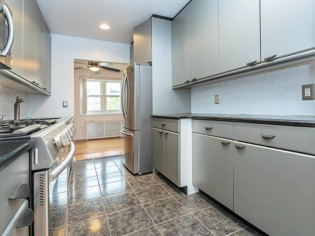 32 Pearsall Ave Unit 3A, Glen Cove, NY 11542 - kitchen featuring stainless steel appliances, dark countertops, ceiling fan, decorative backsplash, and gray cabinetry