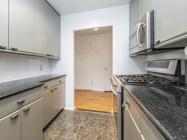 32 Pearsall Ave Unit 3A, Glen Cove, NY 11542 - kitchen with stainless steel appliances, tasteful backsplash, and dark stone countertops