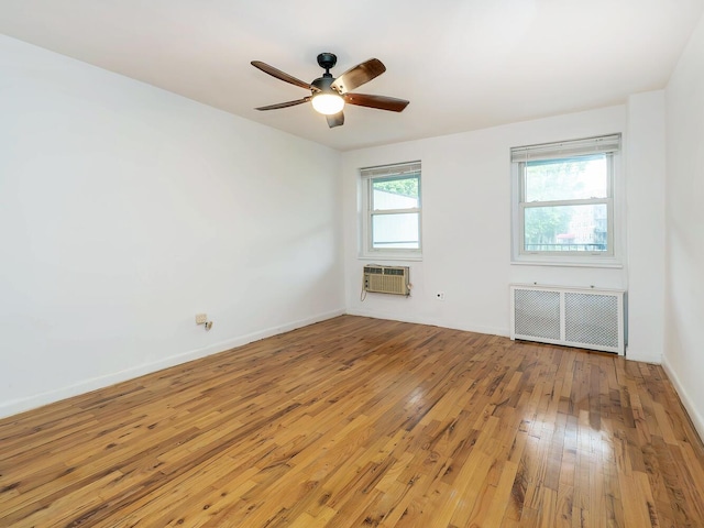 32 Pearsall Ave Unit 3A, Glen Cove, NY 11542 - empty room with radiator heating unit, light wood-style flooring, a ceiling fan, baseboards, and a wall mounted AC