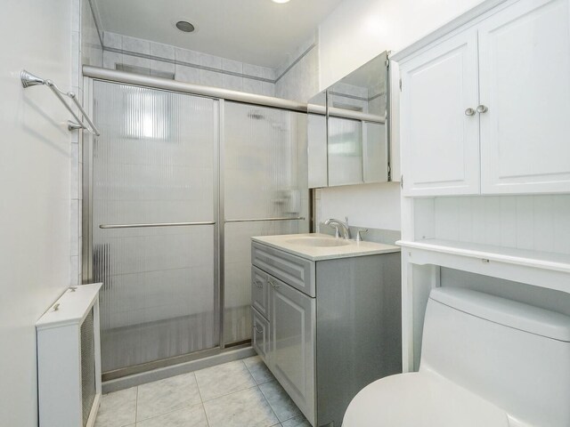 32 Pearsall Ave Unit 3A, Glen Cove, NY 11542 - bathroom featuring toilet, vanity, a stall shower, radiator heating unit, and tile patterned floors