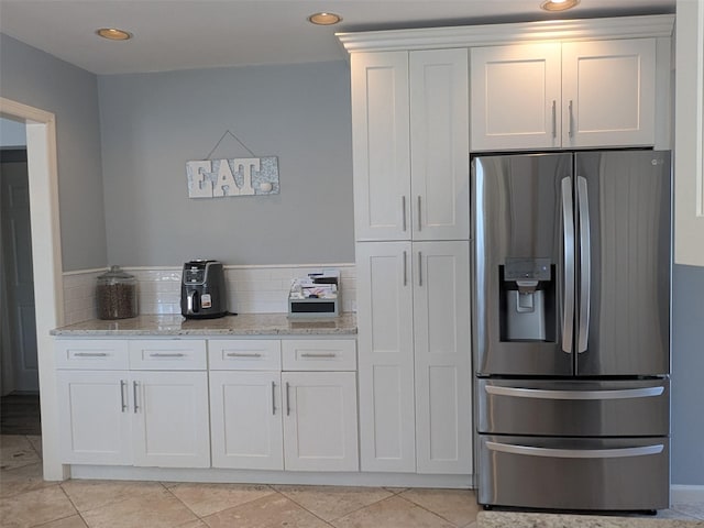 3403 Bay Front Dr, Baldwin, NY 11510 - kitchen with stainless steel refrigerator with ice dispenser, light stone counters, white cabinetry, light tile patterned floors, and recessed lighting