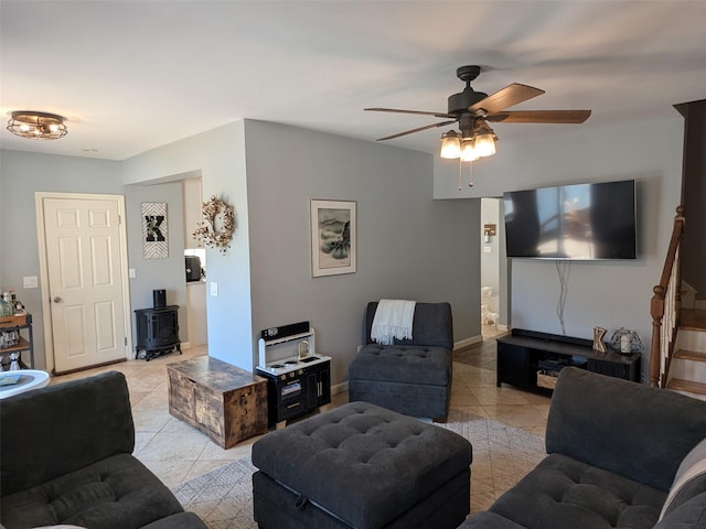 3403 Bay Front Dr, Baldwin, NY 11510 - living area featuring light tile patterned flooring, a wood stove, a ceiling fan, and baseboards