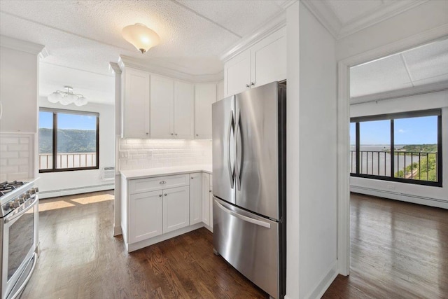 1155 Warburton Ave Unit 12U, Yonkers, NY 10701 - kitchen with appliances with stainless steel finishes, a baseboard radiator, dark wood-type flooring, white cabinets, and crown molding