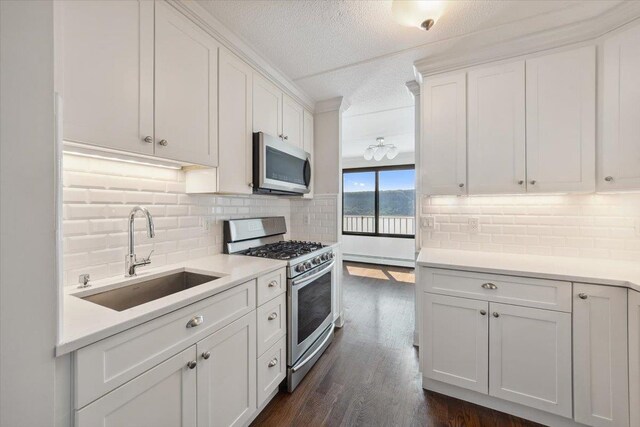 1155 Warburton Ave Unit 12U, Yonkers, NY 10701 - kitchen featuring stainless steel appliances, a sink, baseboard heating, decorative backsplash, and white cabinetry