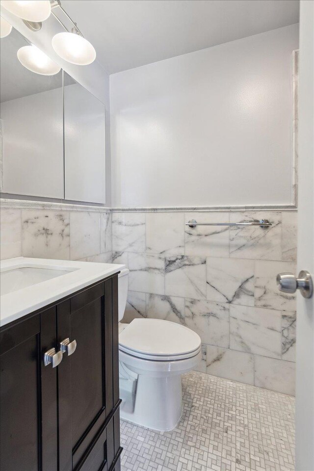 1155 Warburton Ave Unit 12U, Yonkers, NY 10701 - half bathroom with tile walls, toilet, vanity, and a wainscoted wall