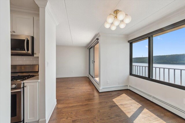 1155 Warburton Ave Unit 12U, Yonkers, NY 10701 - unfurnished dining area with a baseboard heating unit, ornamental molding, a chandelier, baseboards, and dark wood finished floors