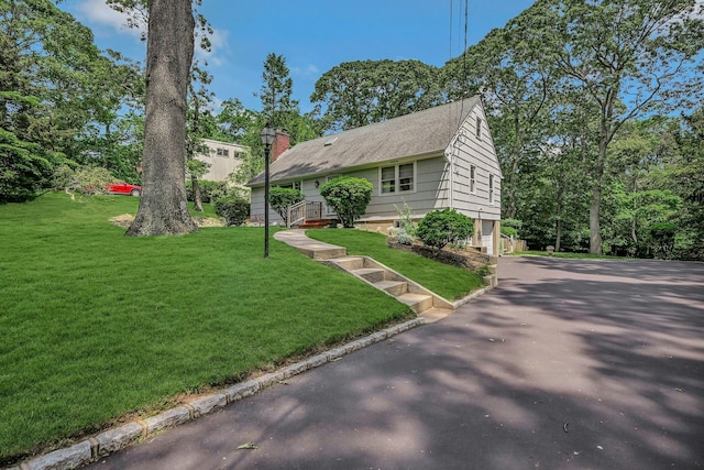 39 Dartmouth Rd, Shoreham, NY 11786 - view of front of home featuring driveway, an attached garage, a front lawn, and a chimney